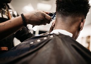 Man getting the back of his head trimmed by a barber